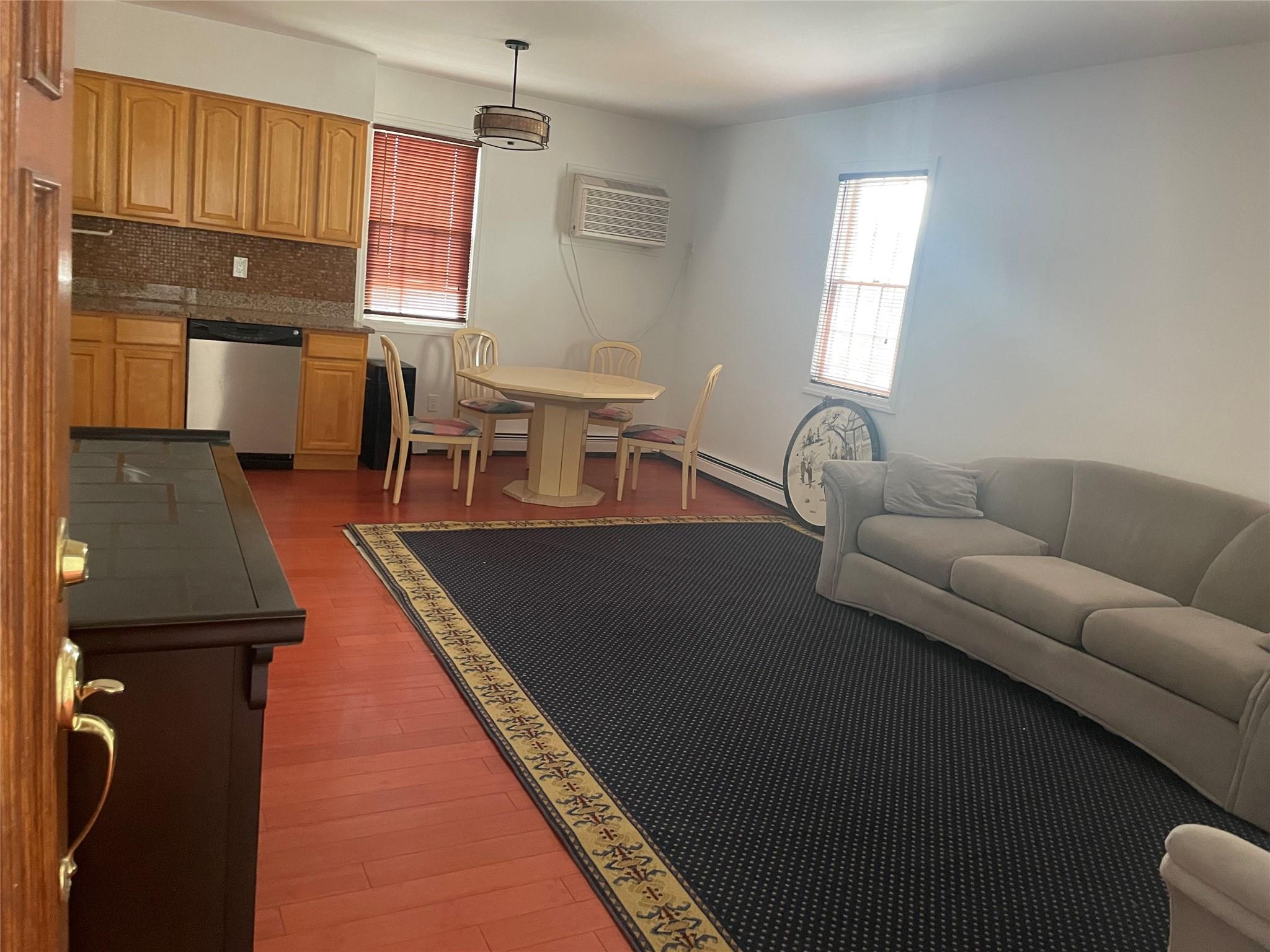 Living room featuring hardwood / wood-style floors and a wall unit AC