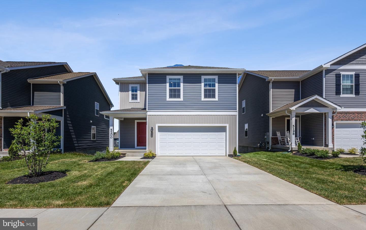 a front view of house with yard and garage