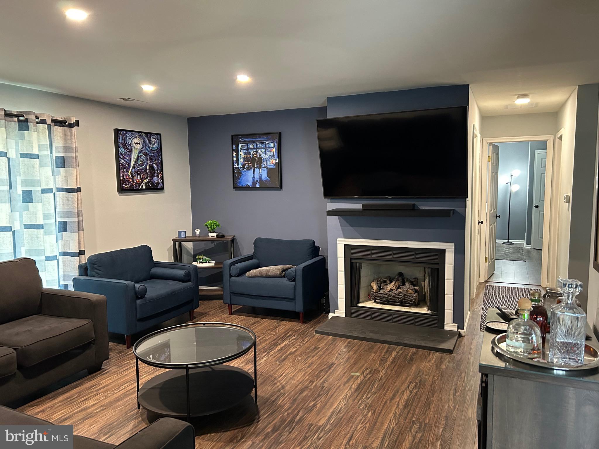 a living room with furniture a flat screen tv and a fireplace