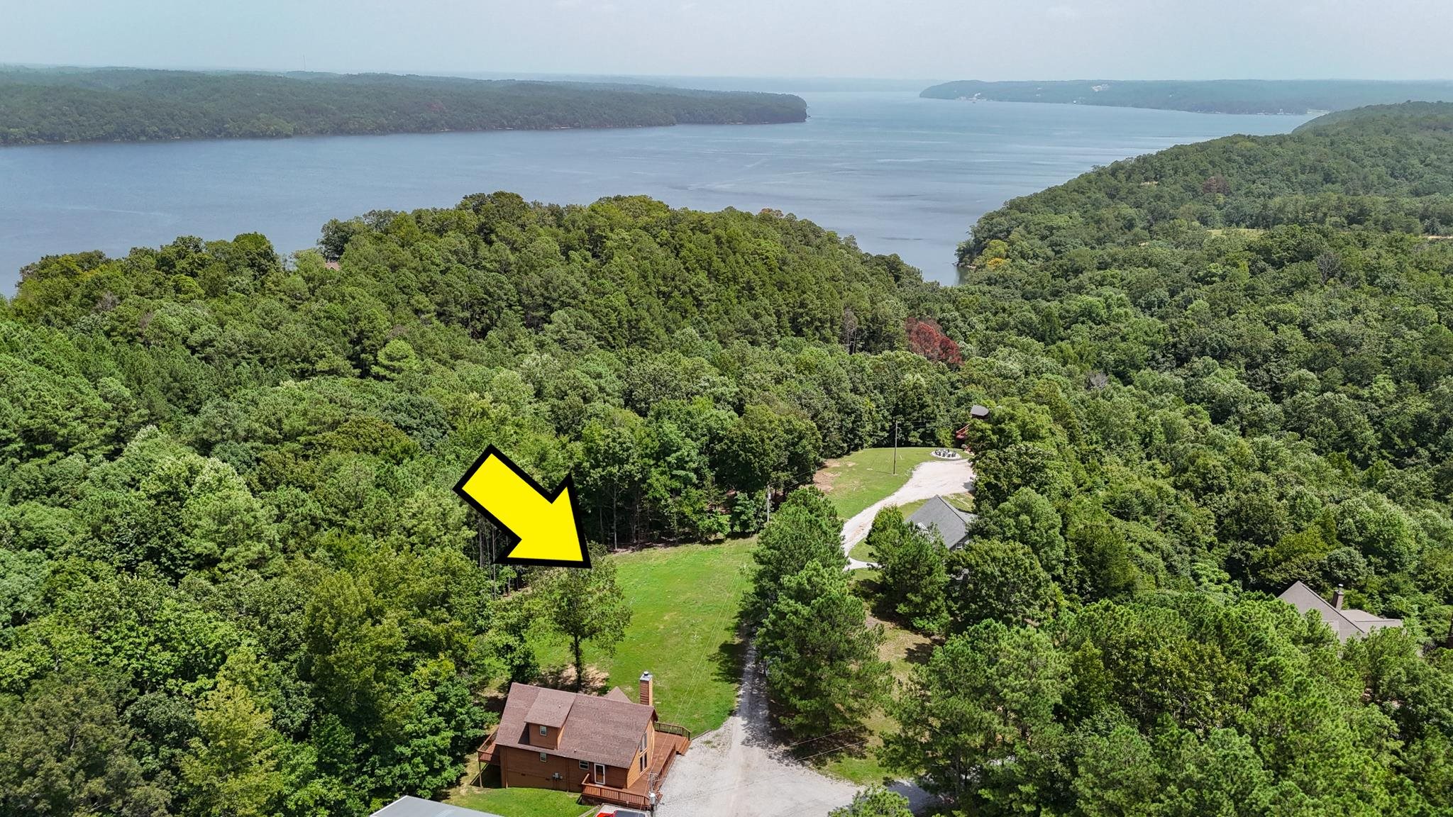 a aerial view of a house with a yard and lake view