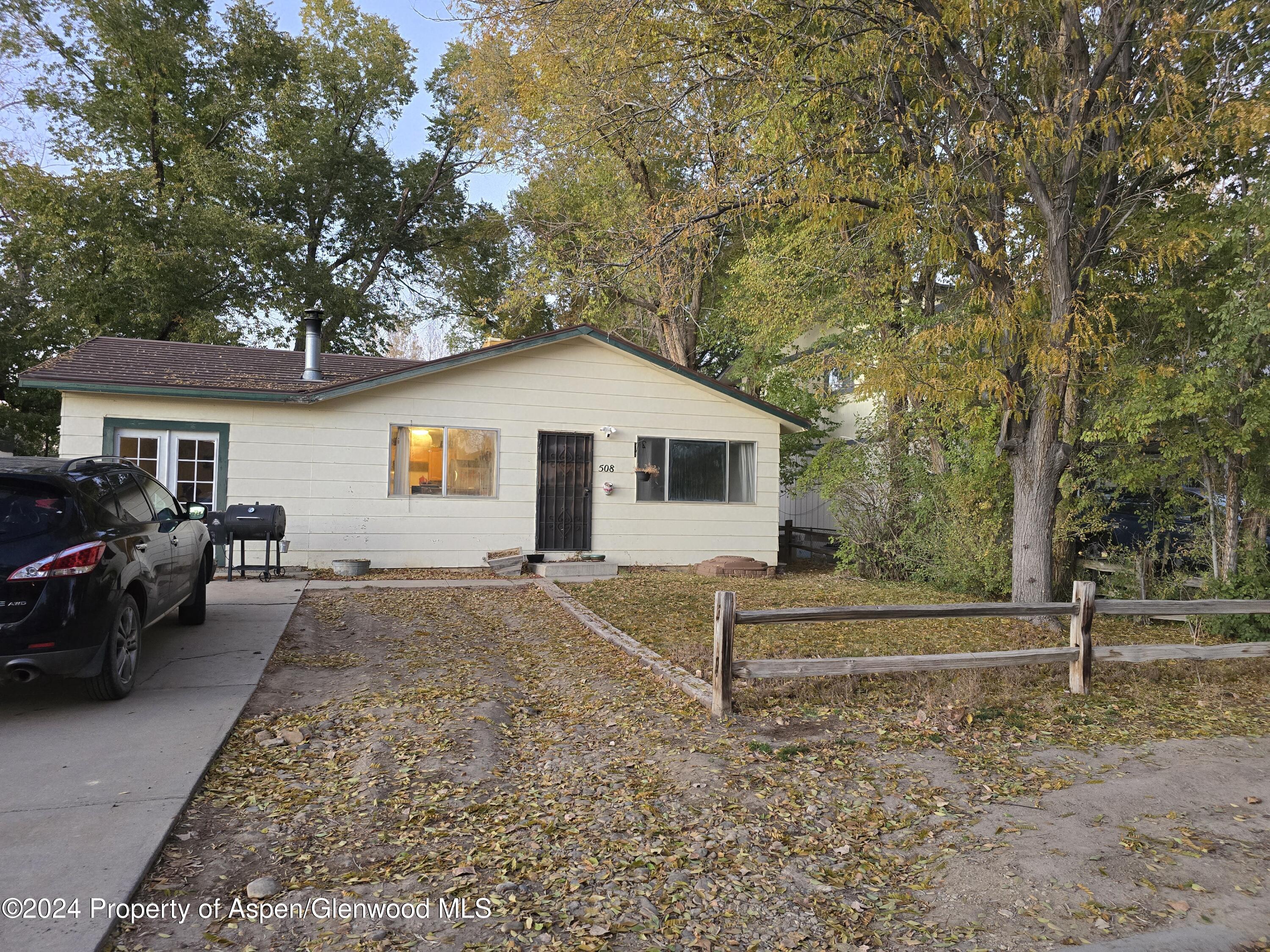 a view of a house with a backyard and a tree