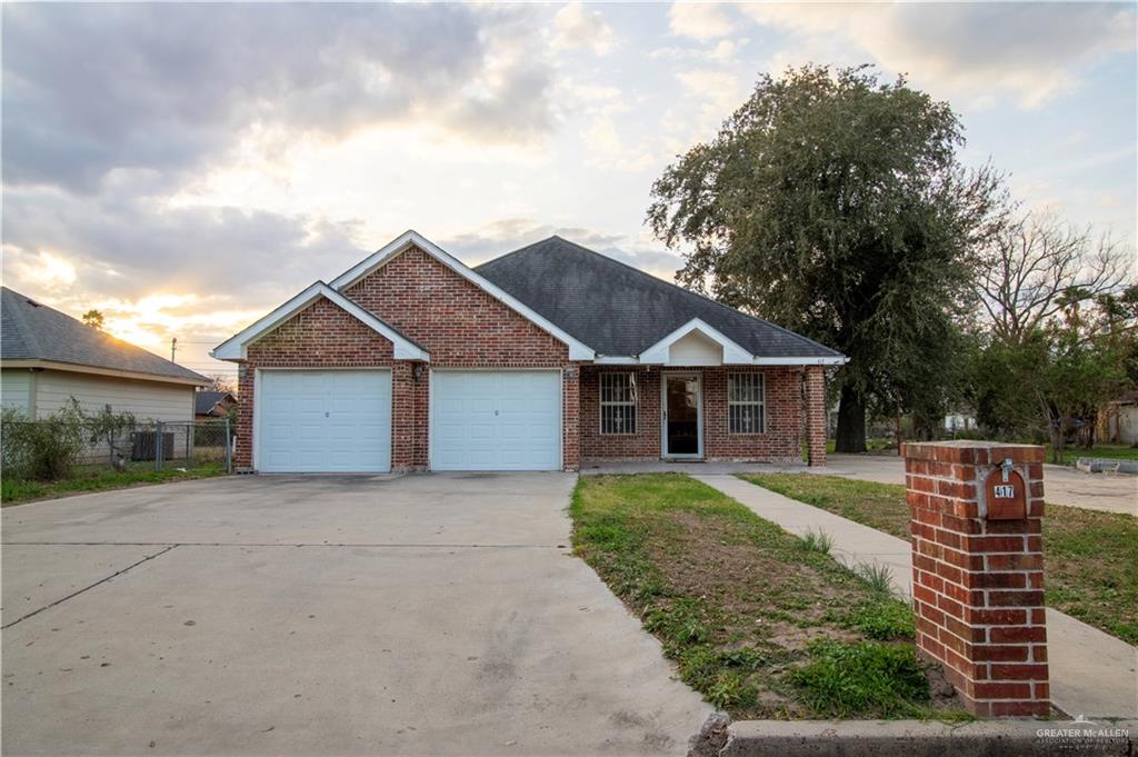 View of front of property featuring central AC and a garage