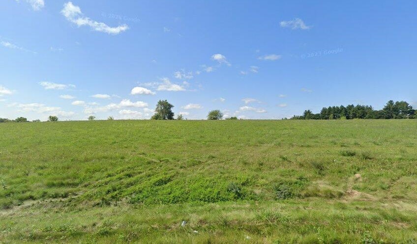 a view of a field with an ocean