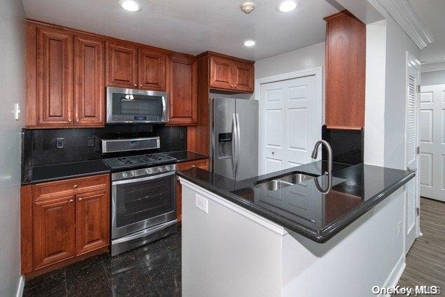 a kitchen with kitchen island granite countertop a sink stove and refrigerator