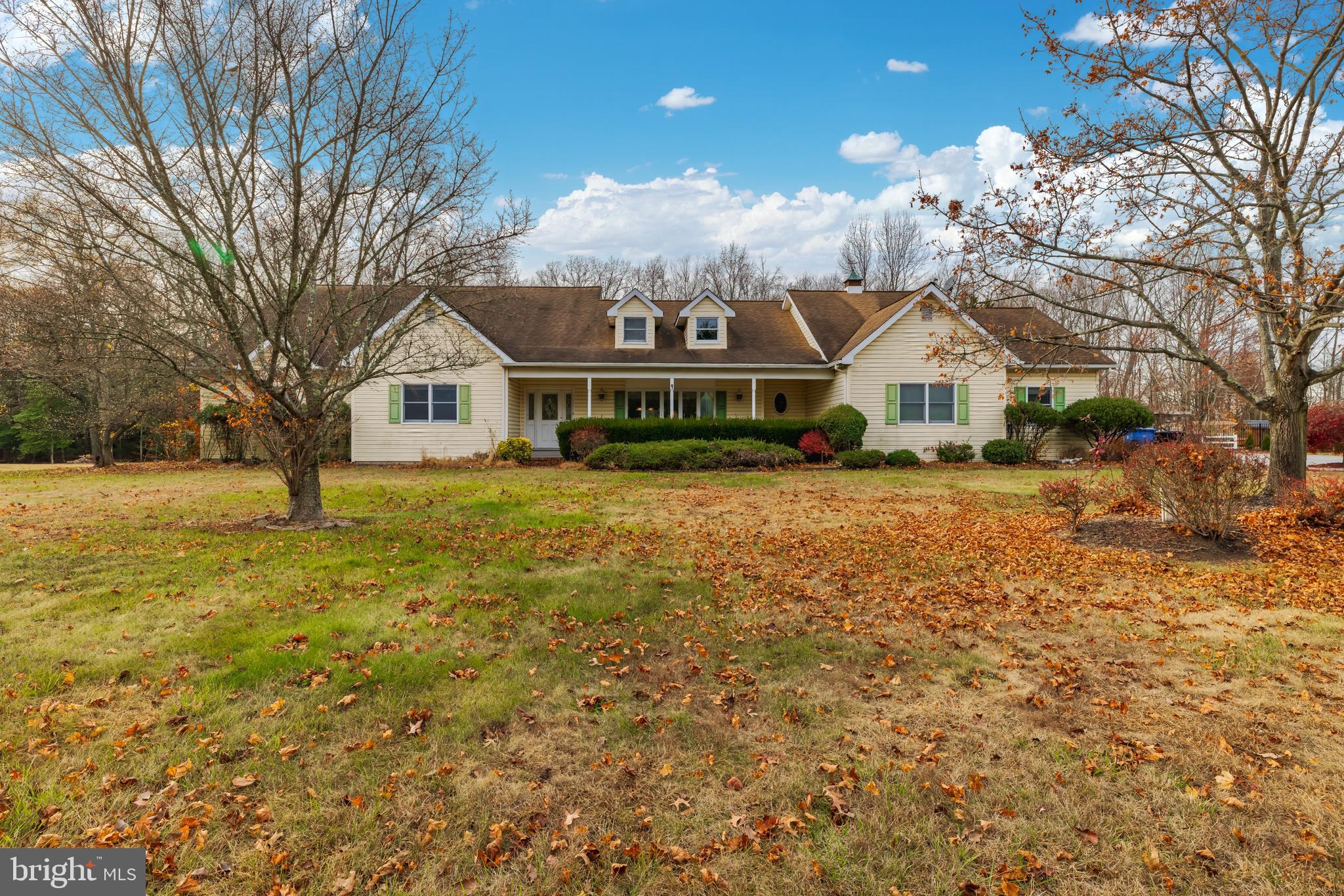 a front view of a house with a yard and trees