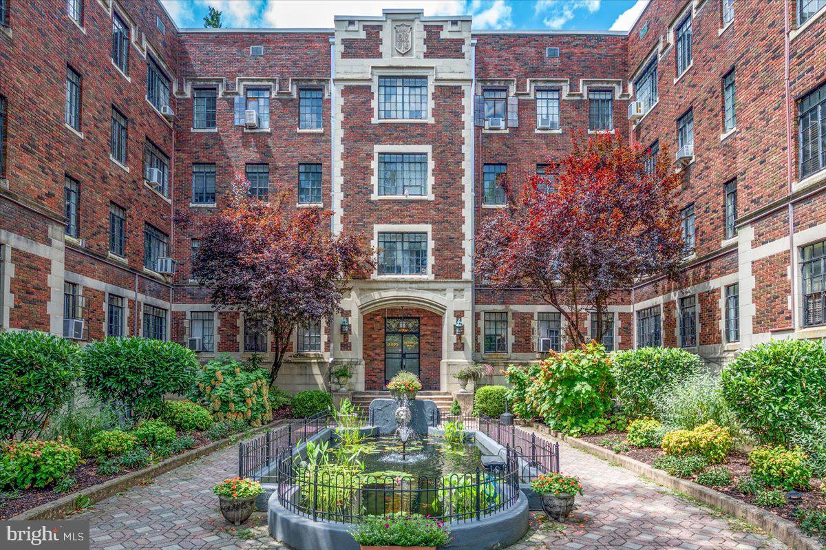 a front view of a building with garden and plants