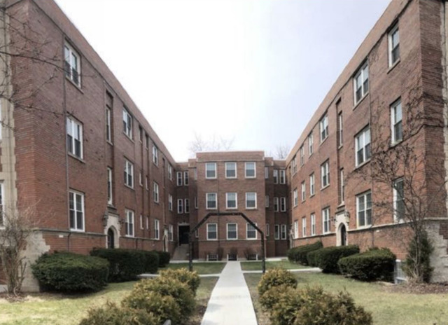 a view of a brick building next to a yard