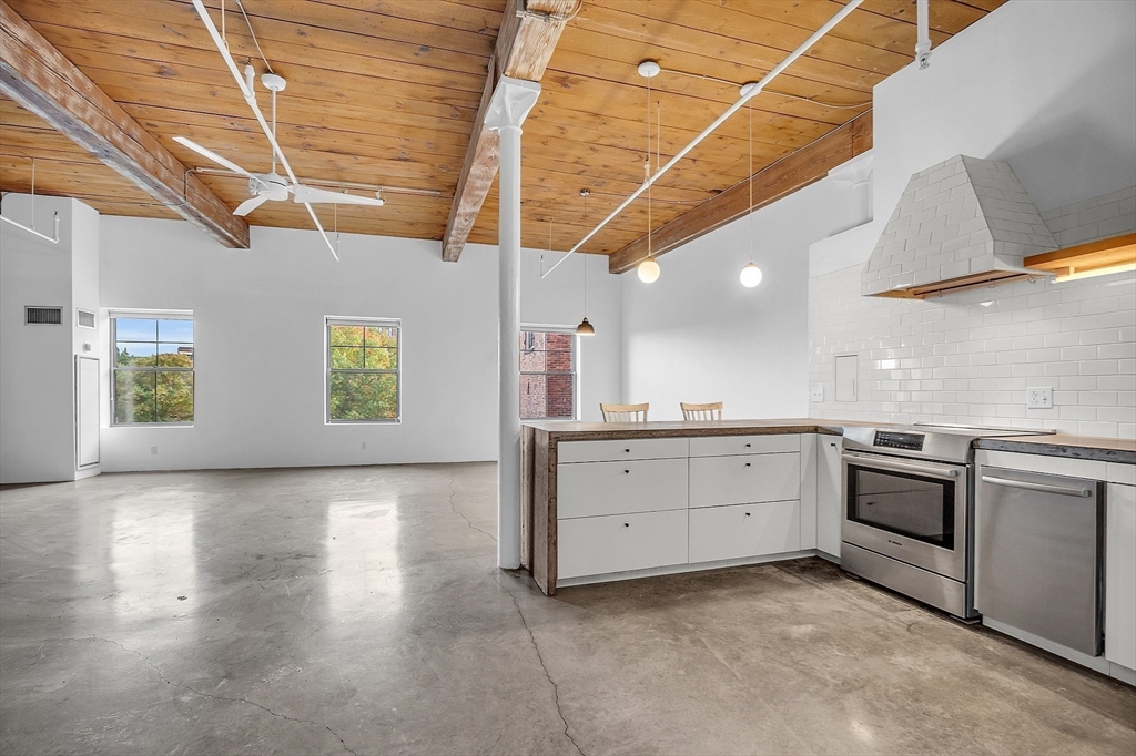 a kitchen with granite countertop a stove sink and cabinets