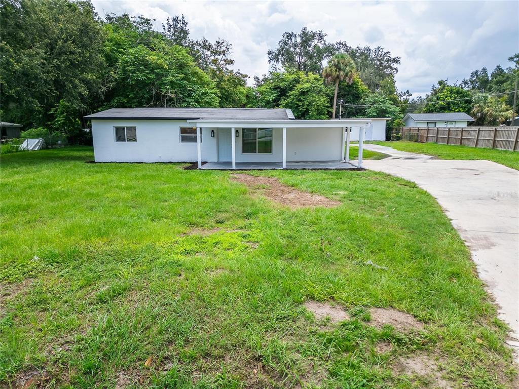 a view of a house with a backyard and a small garden