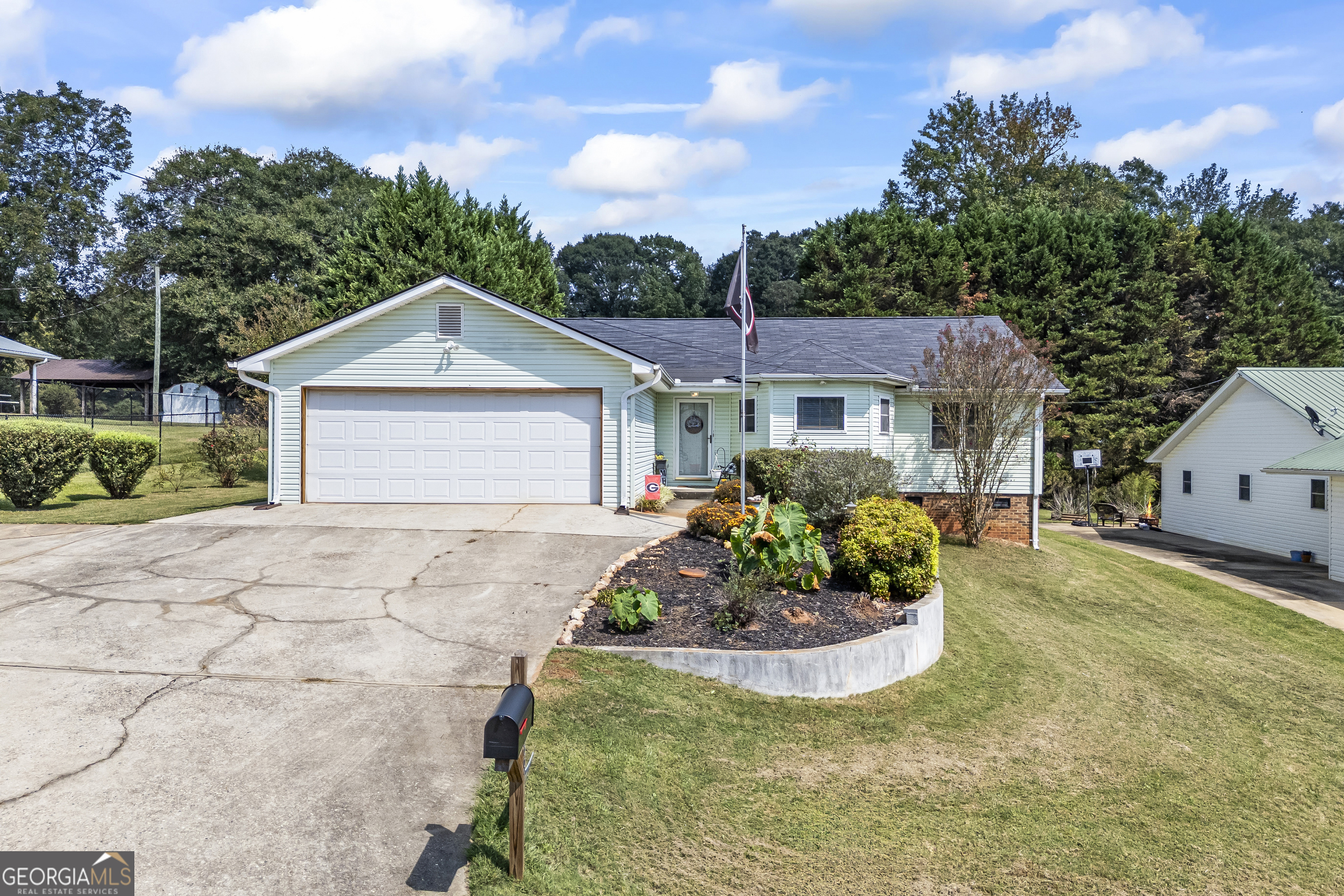 a front view of a house with a garden and mountain view