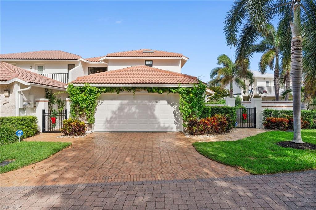 a front view of a house with a yard and potted plants