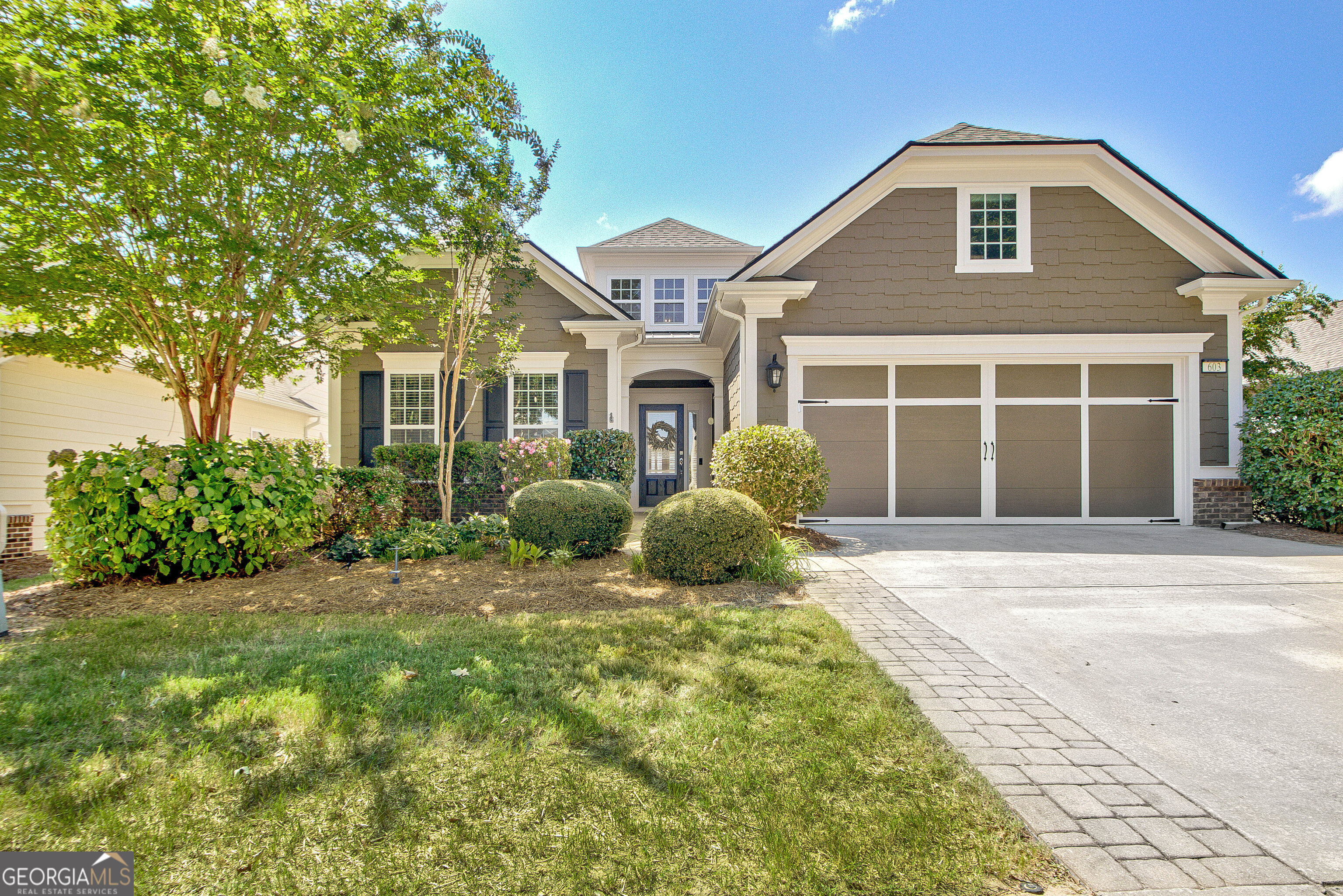 a front view of a house with a garden