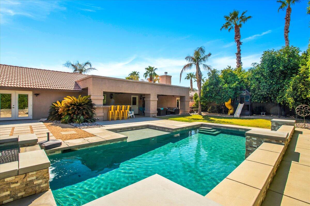 a view of a house with swimming pool and a yard