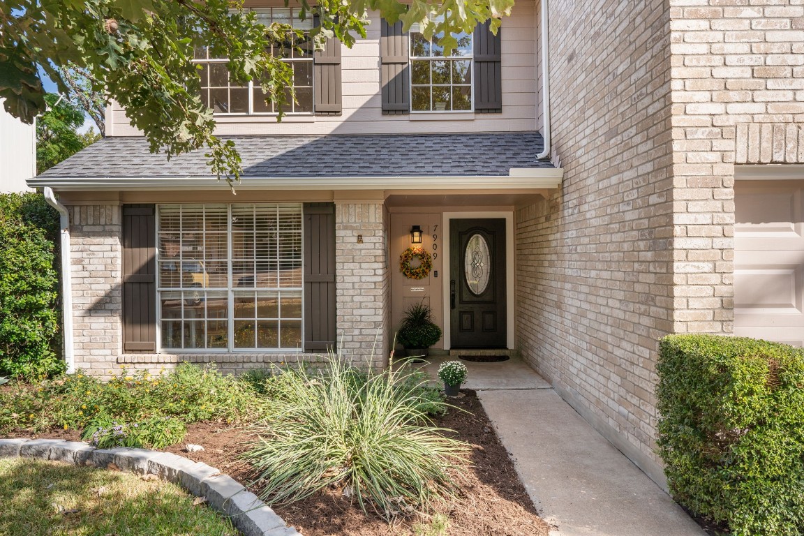 a view of a brick house with plants