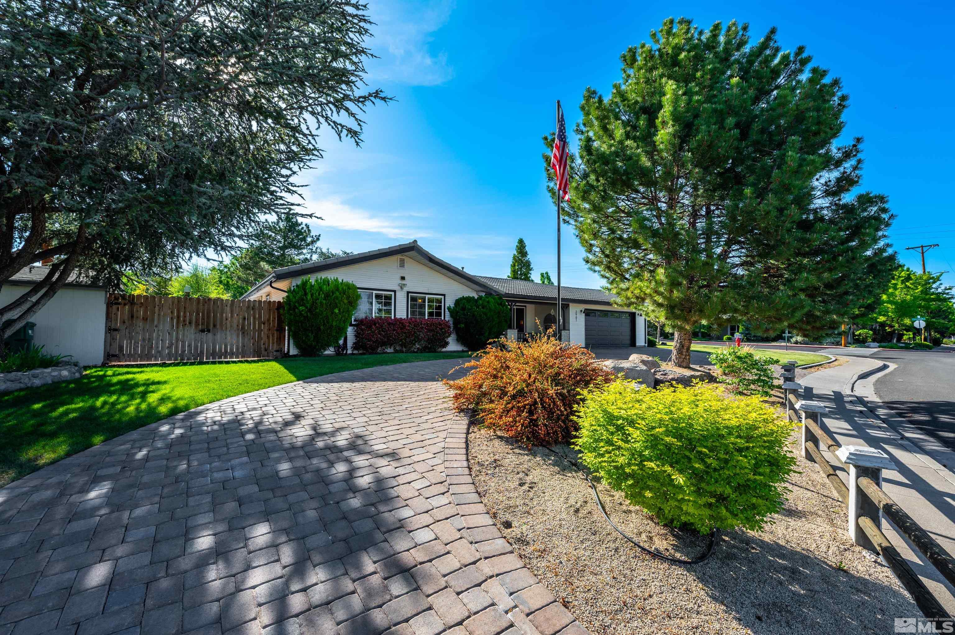 a front view of a house with a yard and a garden