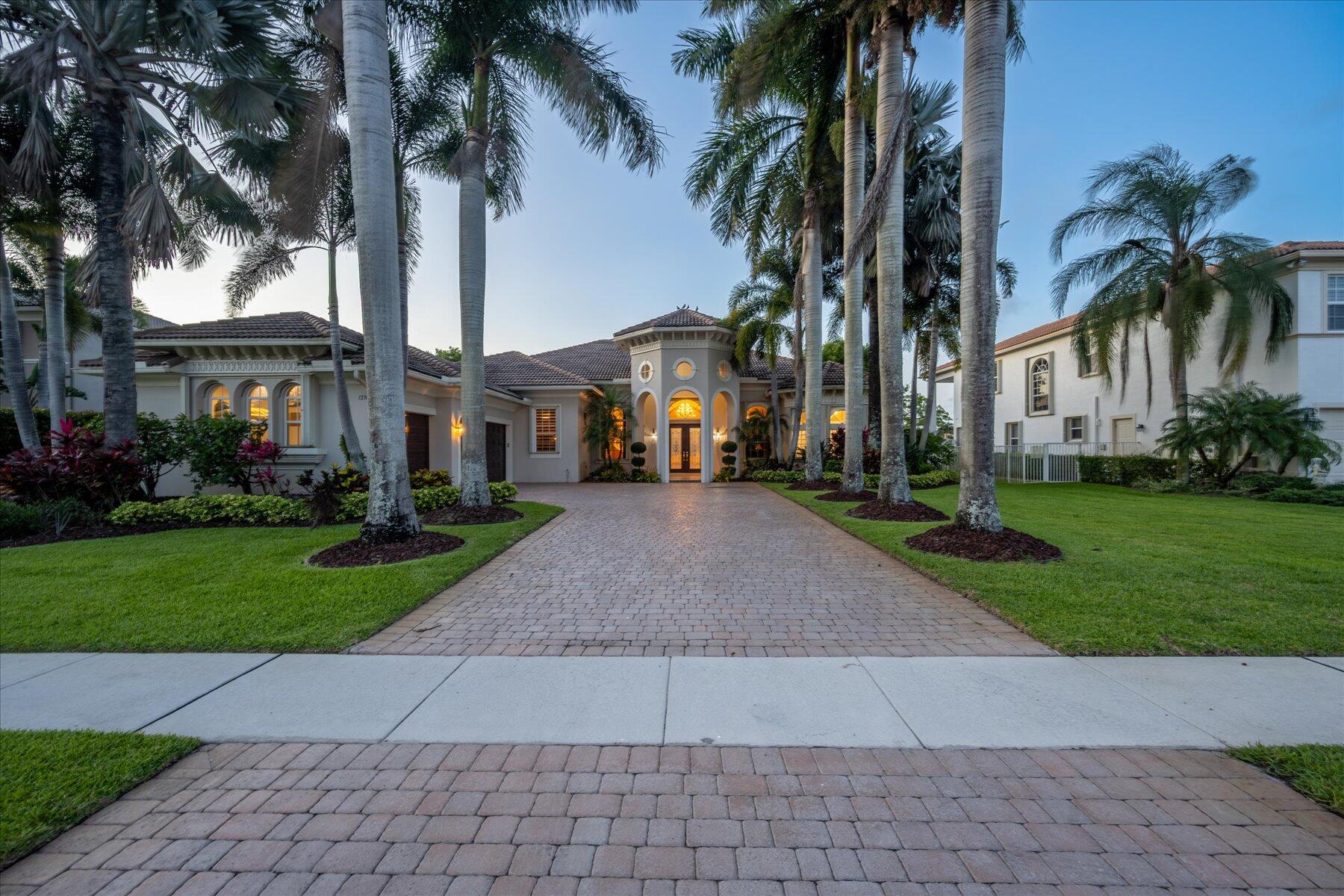 front view of house with a yard and palm trees