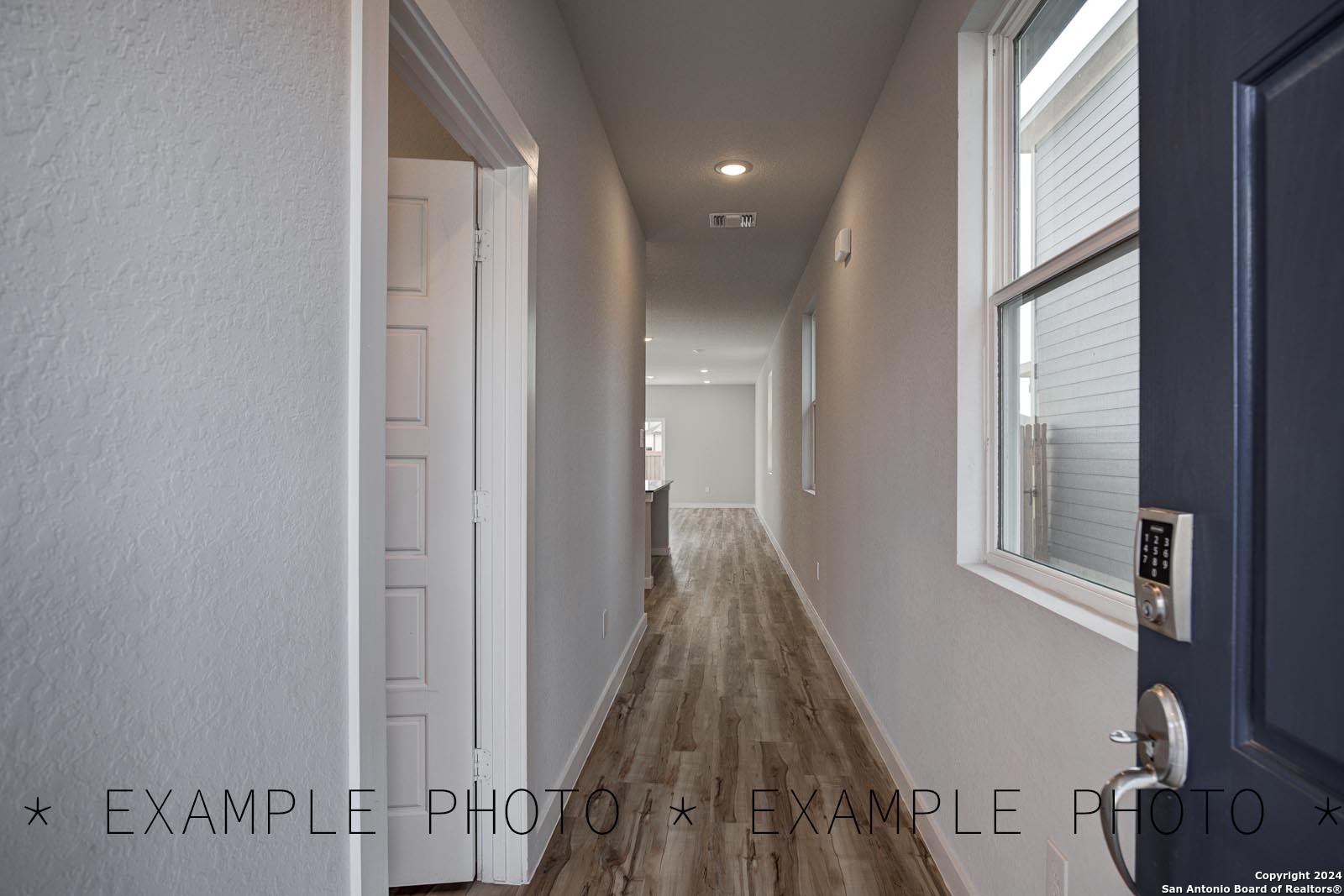 a view of a hallway with wooden floor and staircase