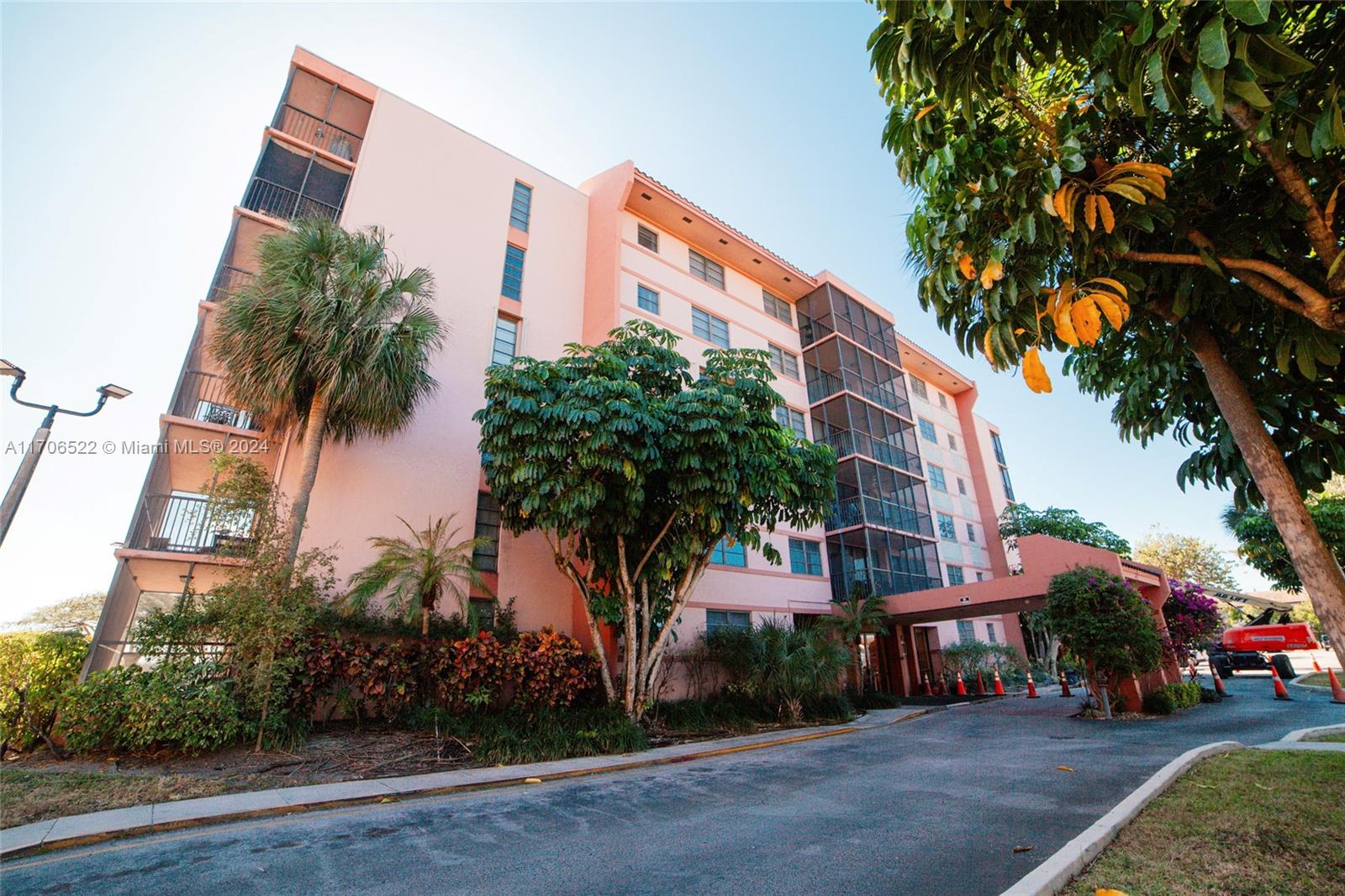 a front view of a building with palm trees