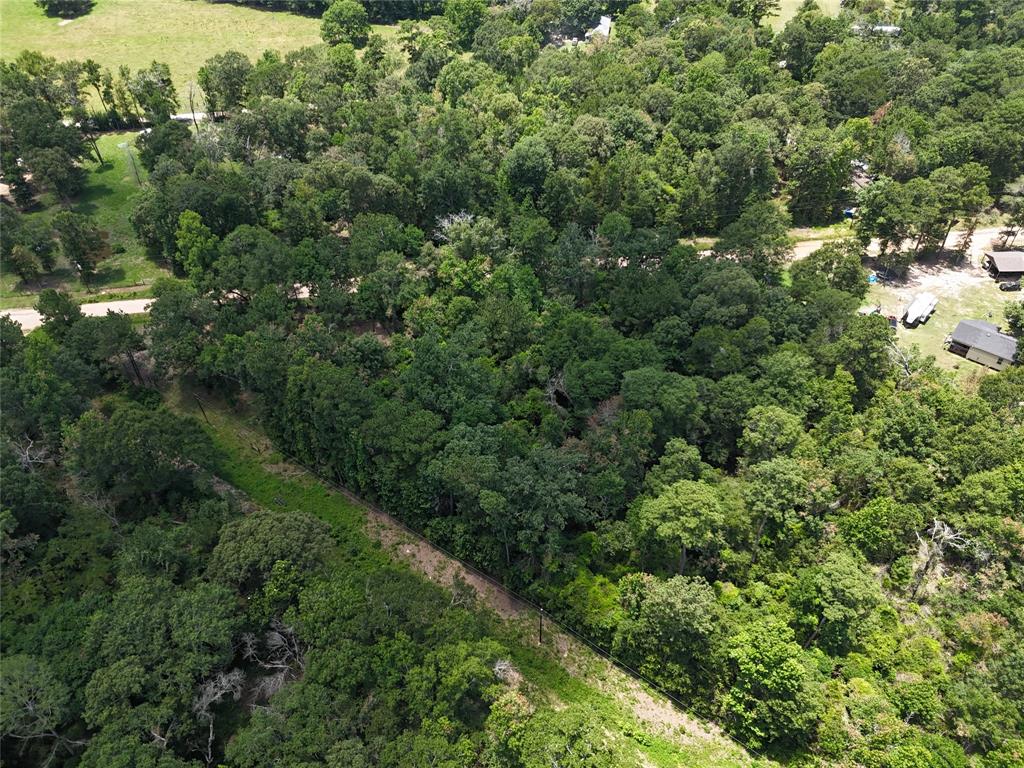 an aerial view of residential house with outdoor space and trees all around