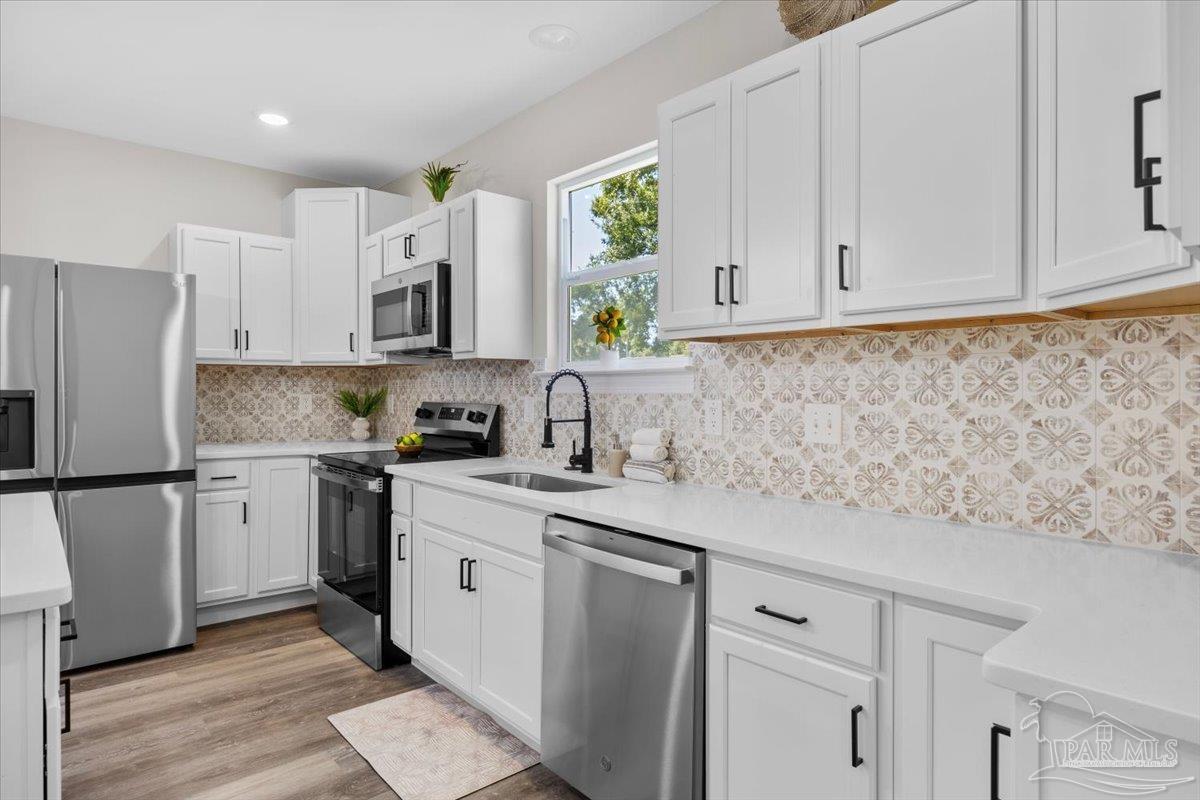 a kitchen with appliances cabinets and a sink