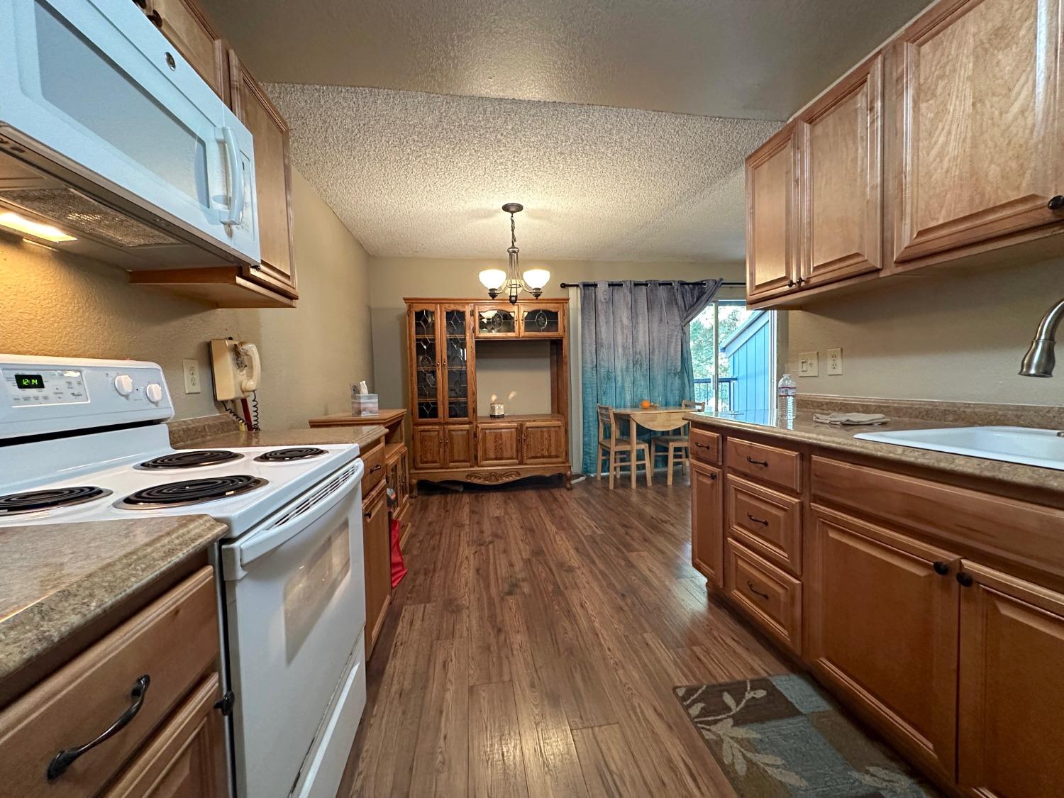 a kitchen with granite countertop wooden floors and stainless steel appliances