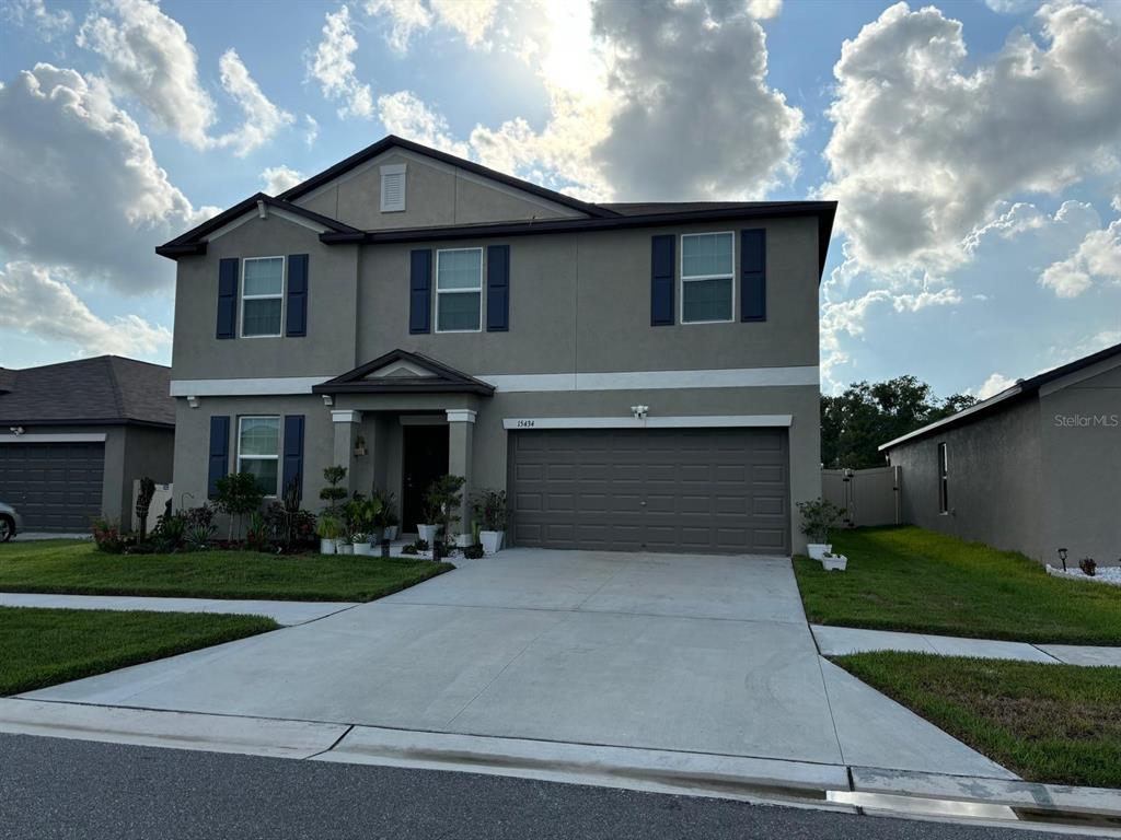 a front view of a house with a yard and garage