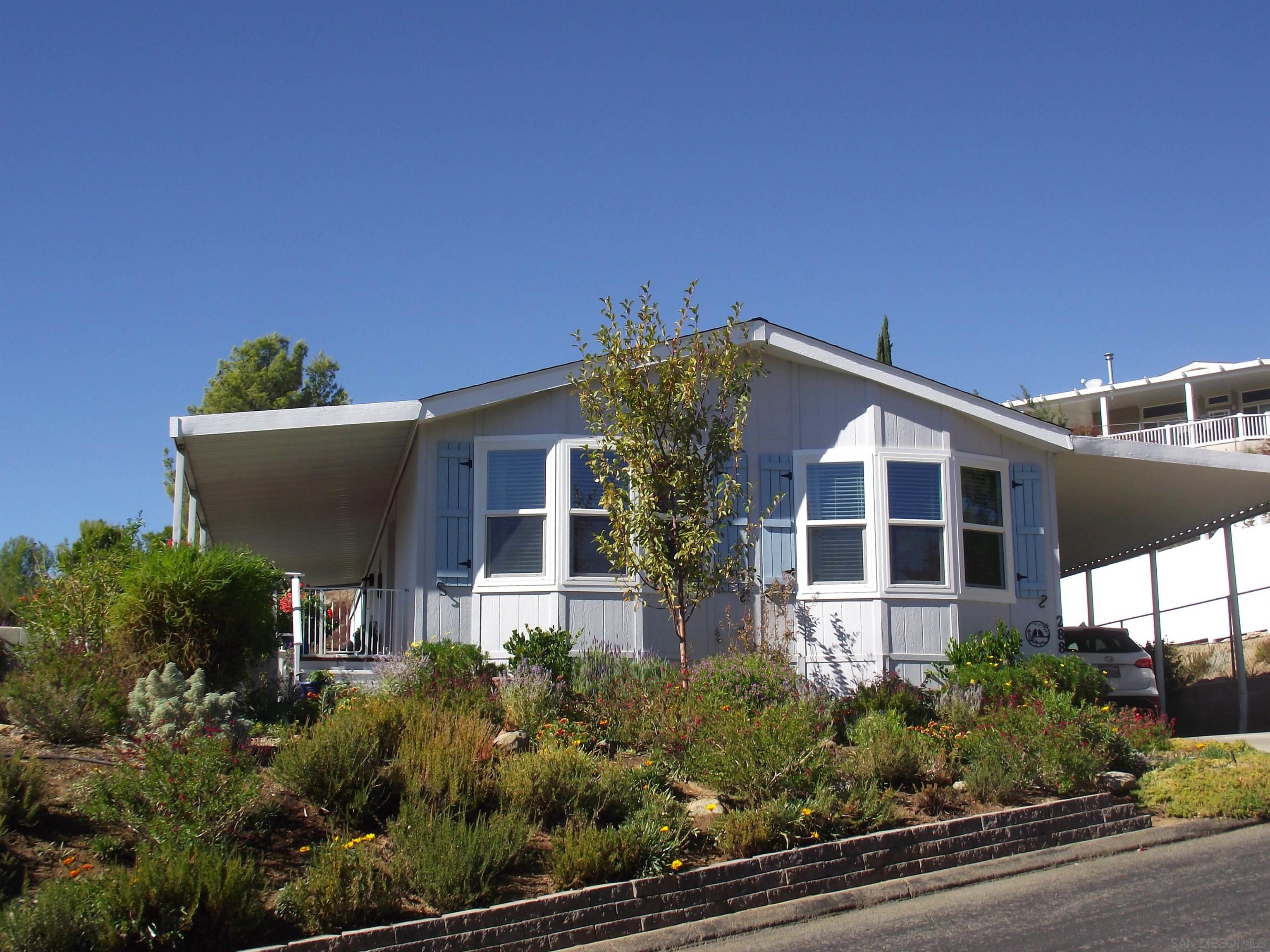 a view of a house with a yard and potted plants