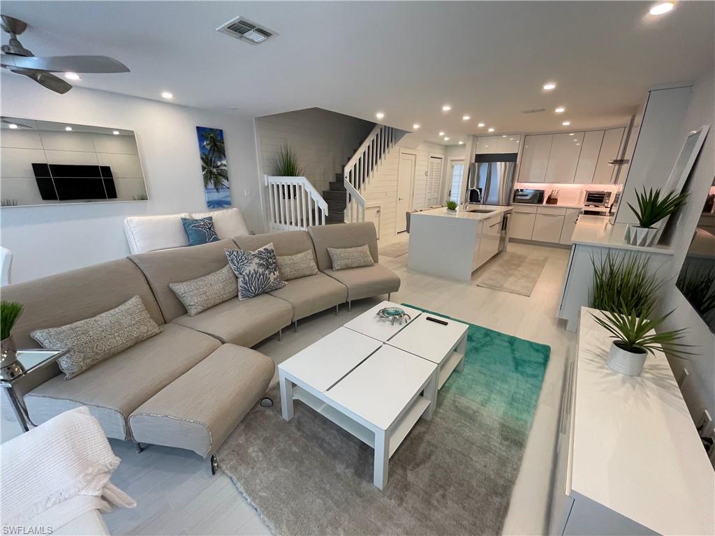 Living room with sink, light hardwood / wood-style flooring, and ceiling fan