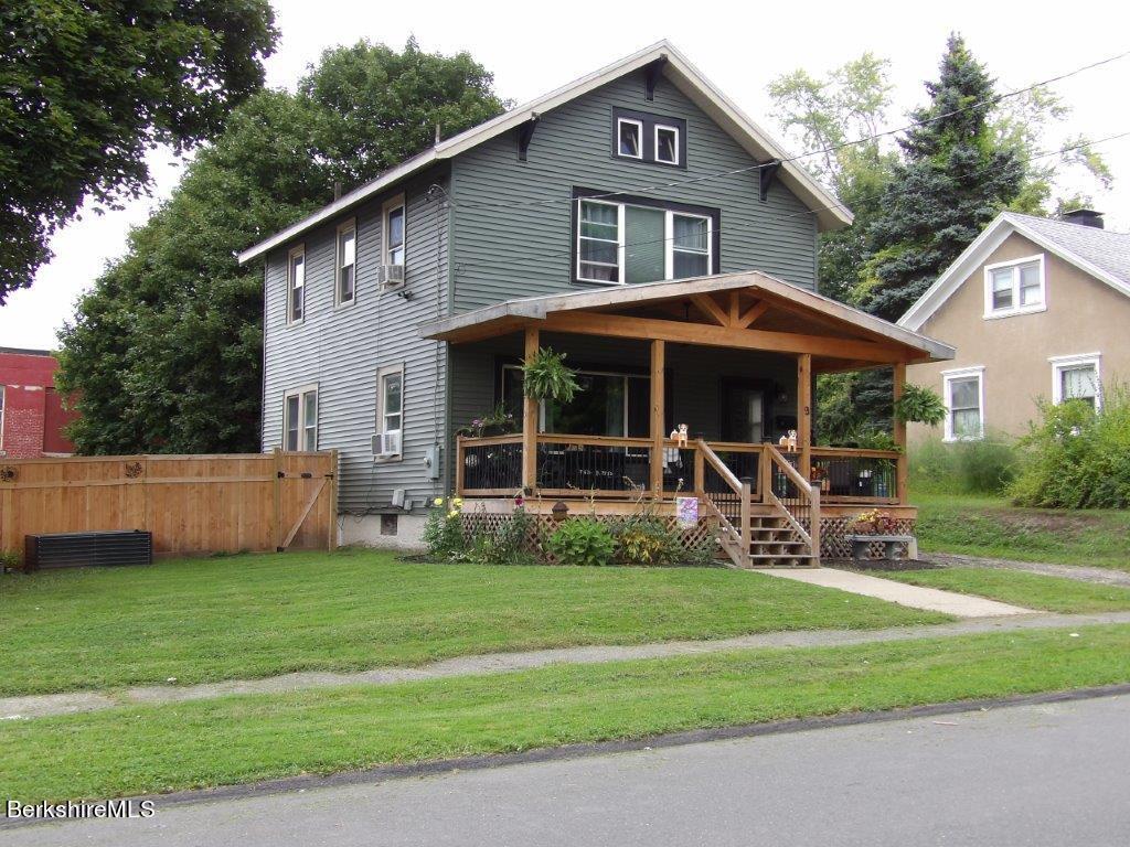 a view of a house with a yard and sitting area