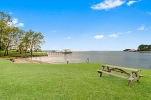 a view of a lake with a bench and trees in the background