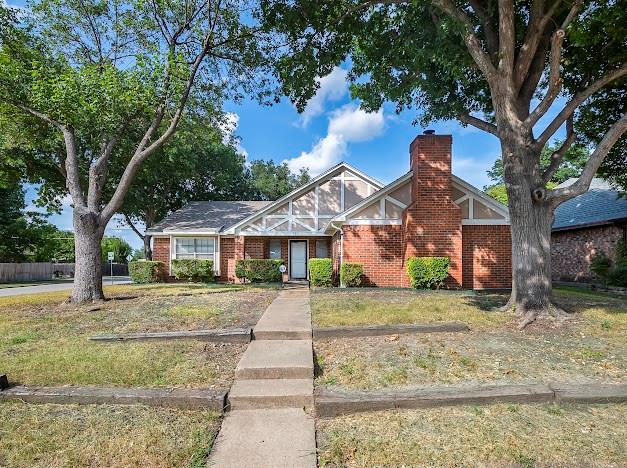 a front view of a house with a yard covered with trees