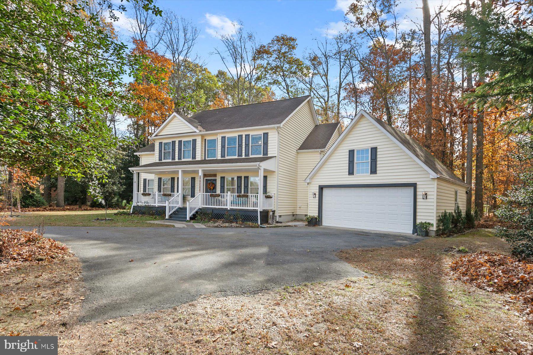 a front view of a house with a yard and trees