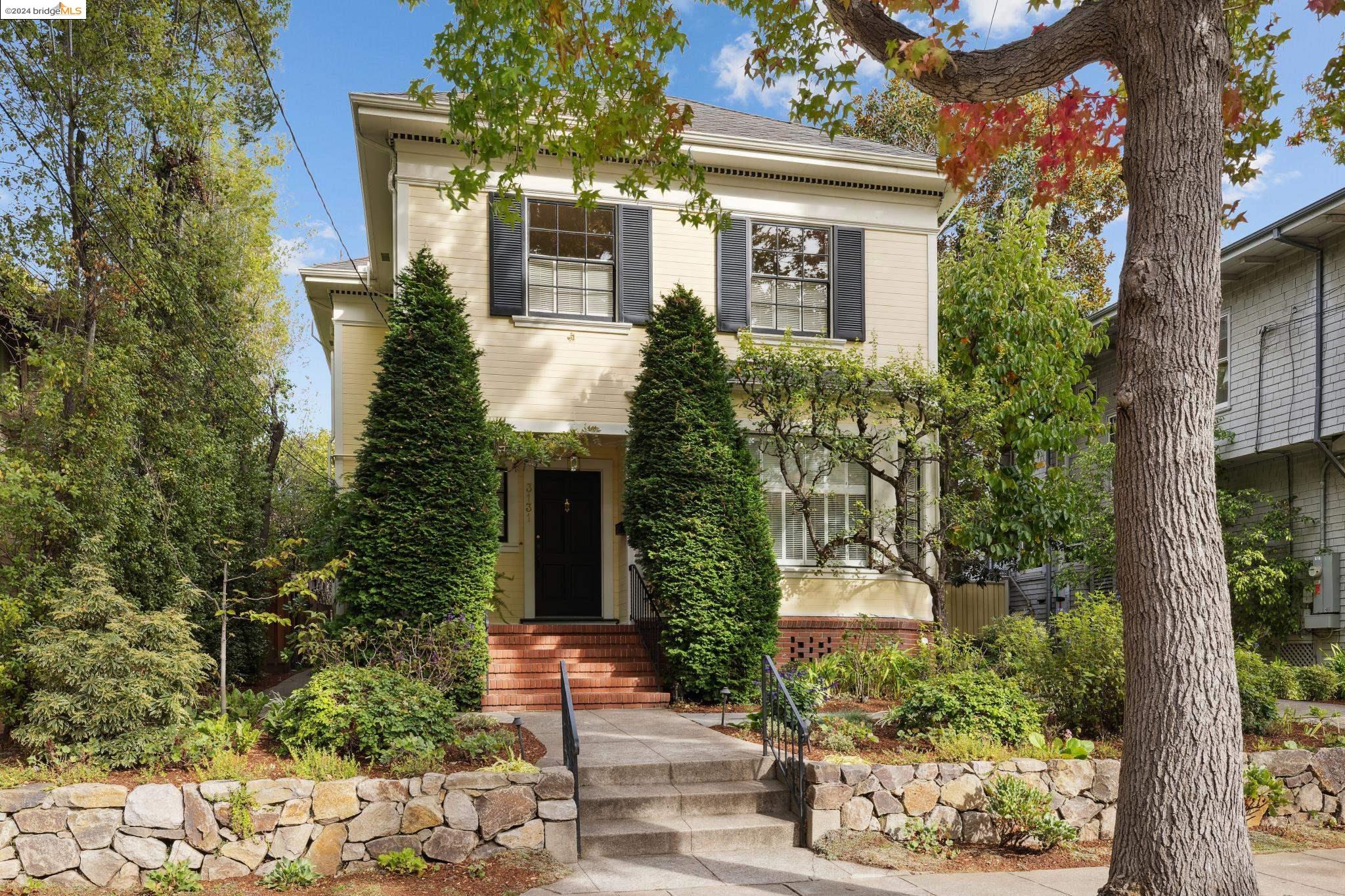 a front view of a house with a tree in front