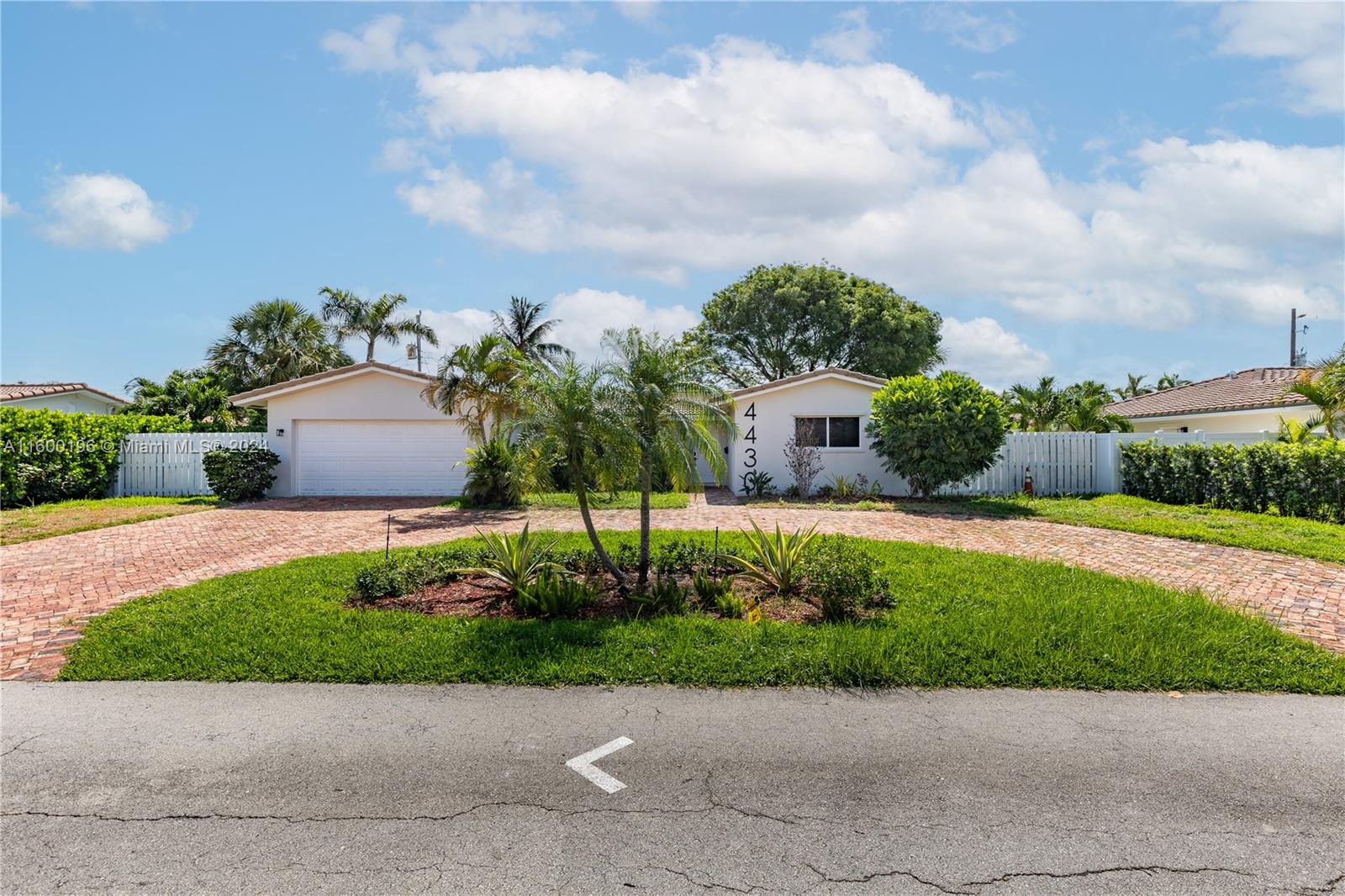 a front view of a house with a yard and potted plants