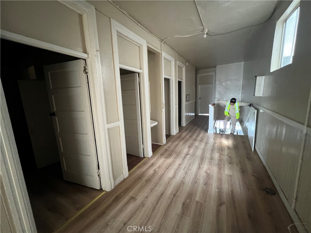 a view of a hallway with wooden floor and furniture