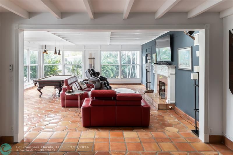 a living room with furniture fireplace and large windows