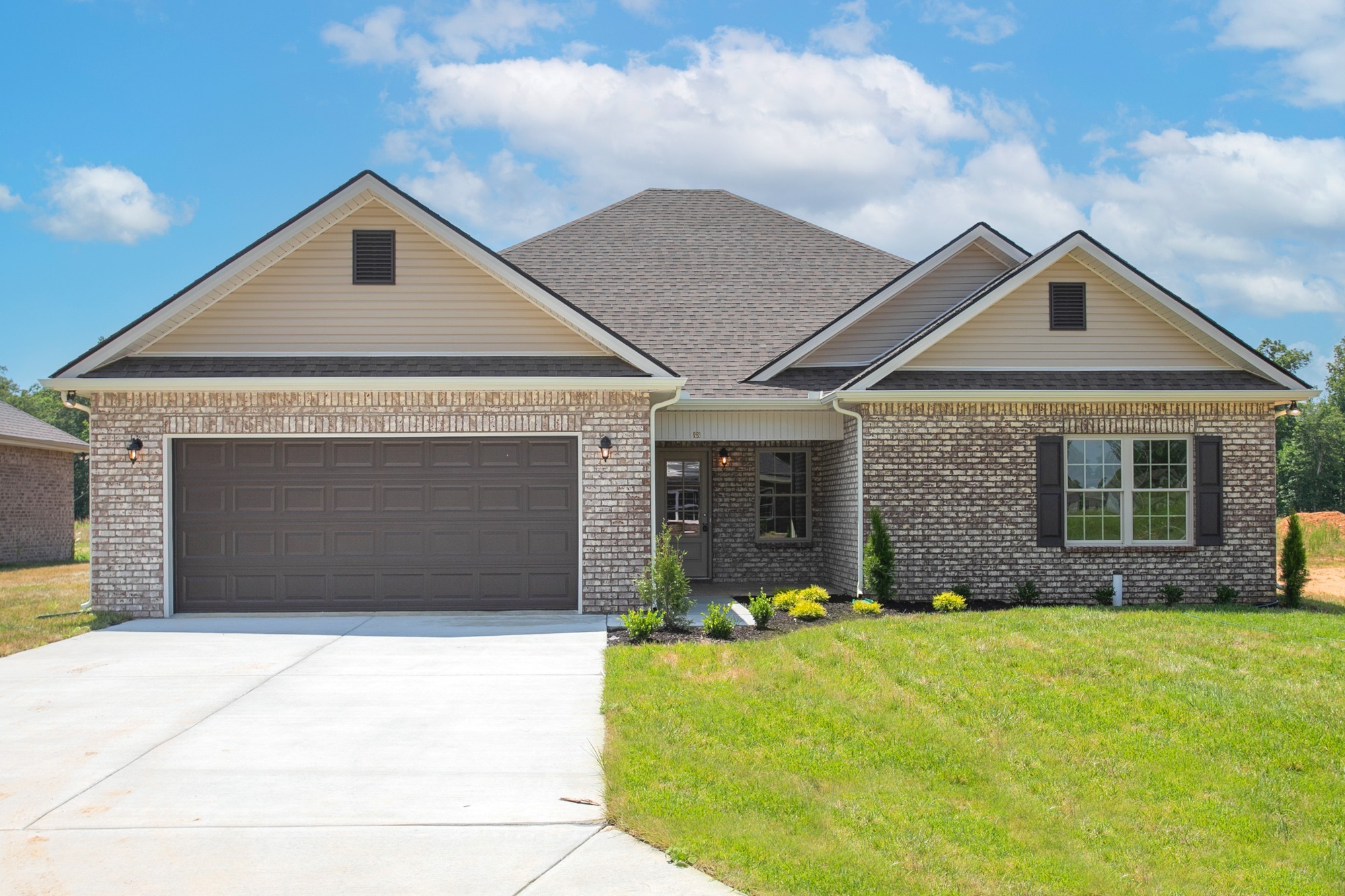 a front view of a house with yard and garage