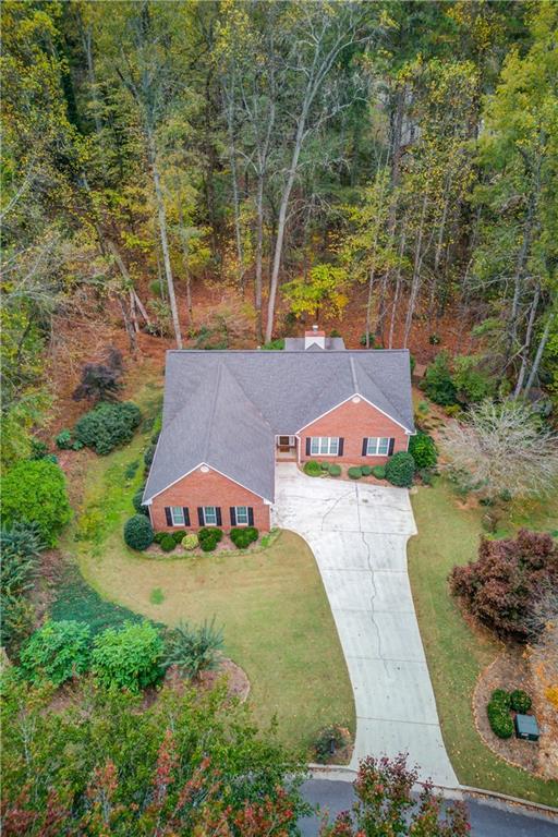 an aerial view of a house with garden space and trees