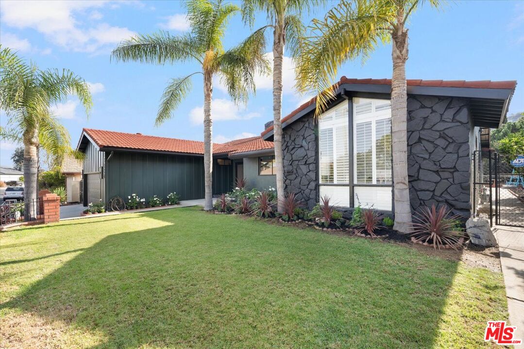 a front view of a house with a garden and yard