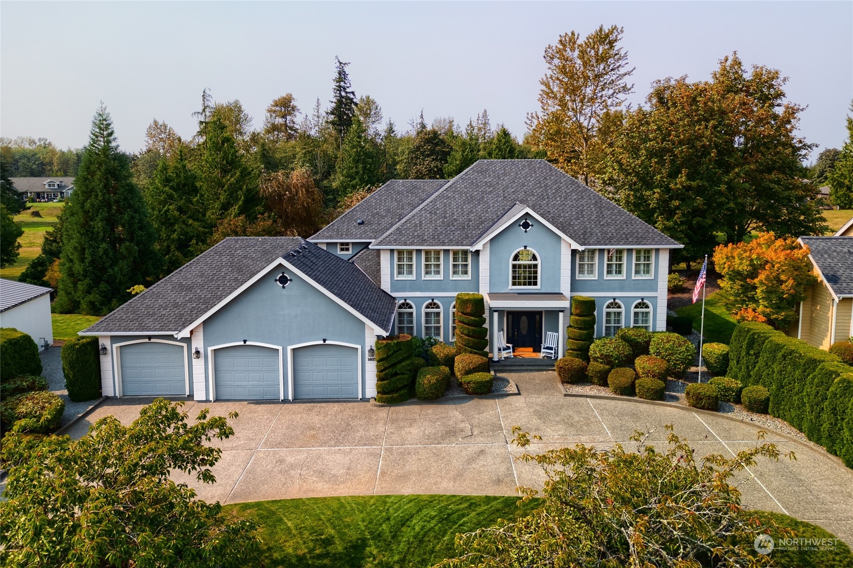 a view of house with yard and trees in the background