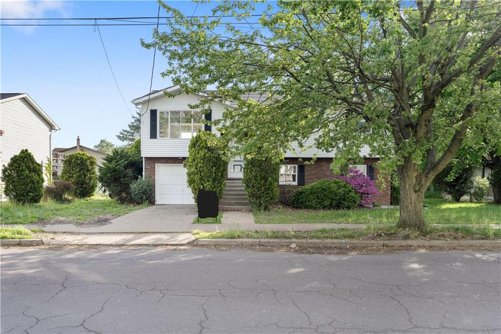 a front view of a house with a yard and a garage