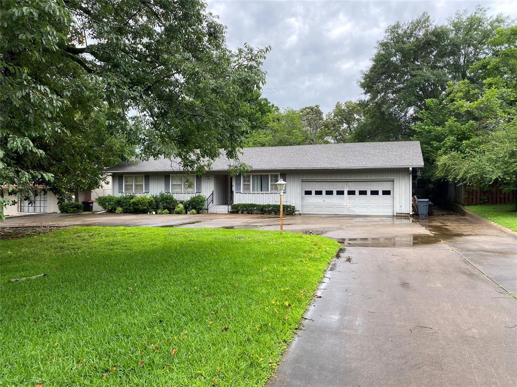 a front view of a house with a yard and green space