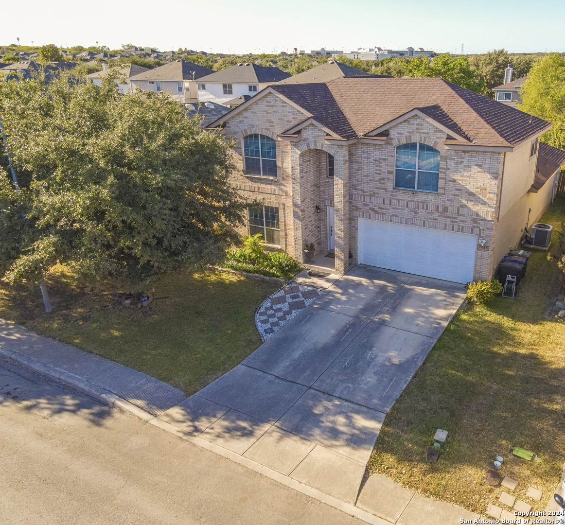 a view of a big house with a big yard and large tree