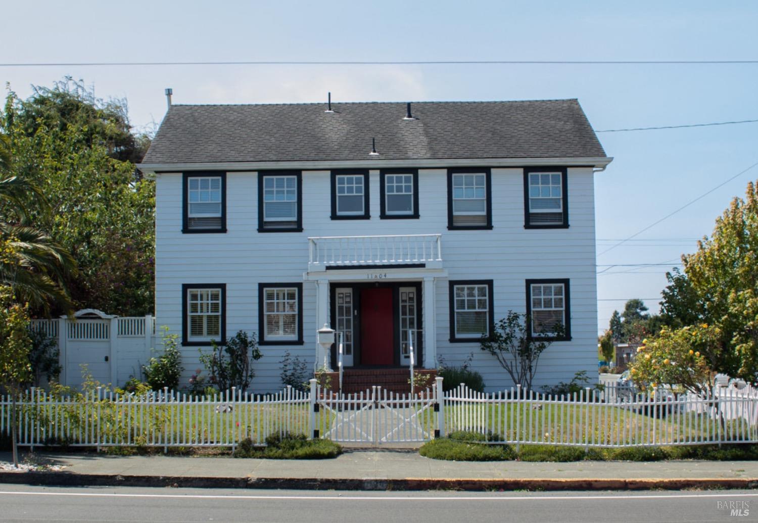 a front view of a house with a garden and plants