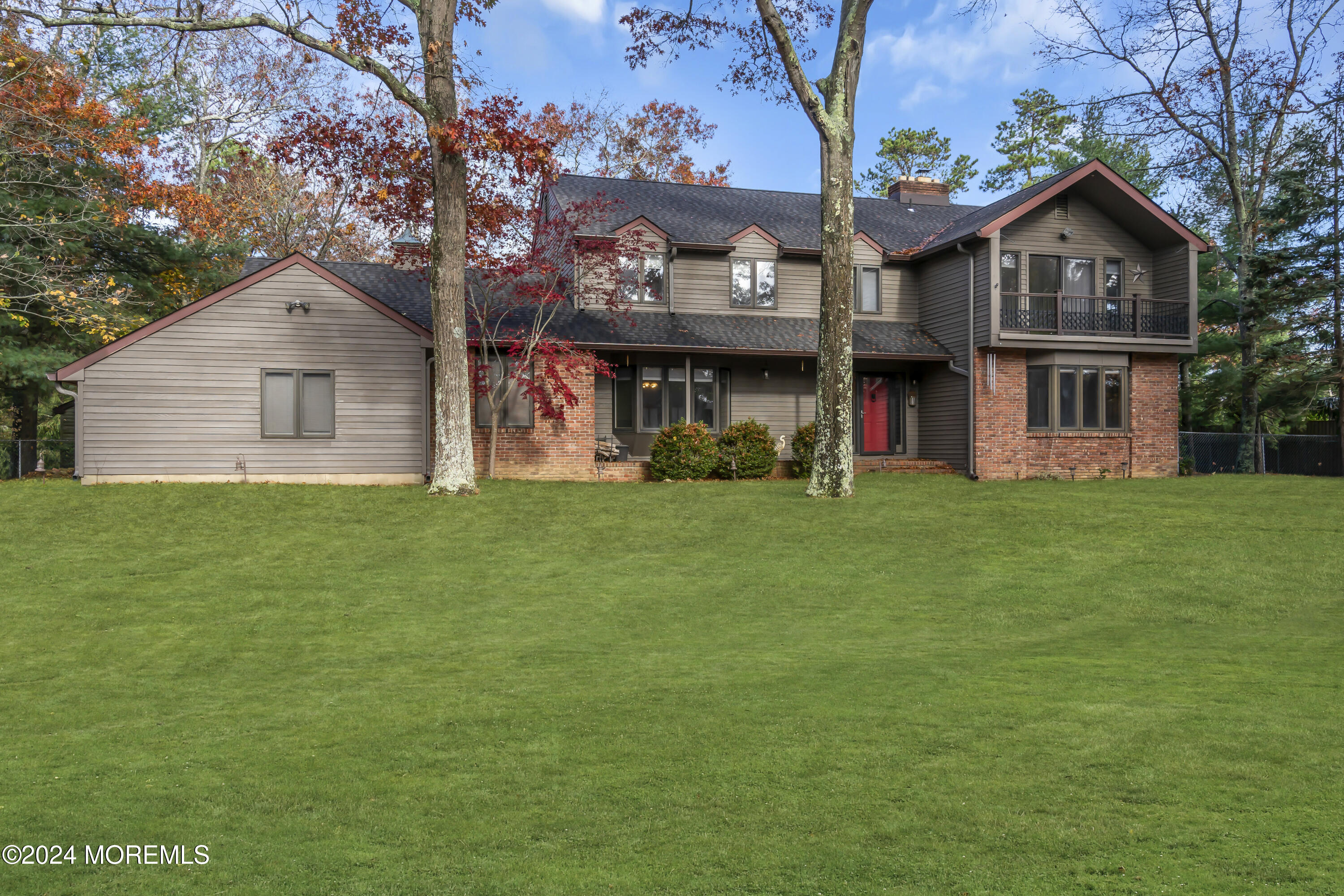 a view of a house with a big yard and large trees