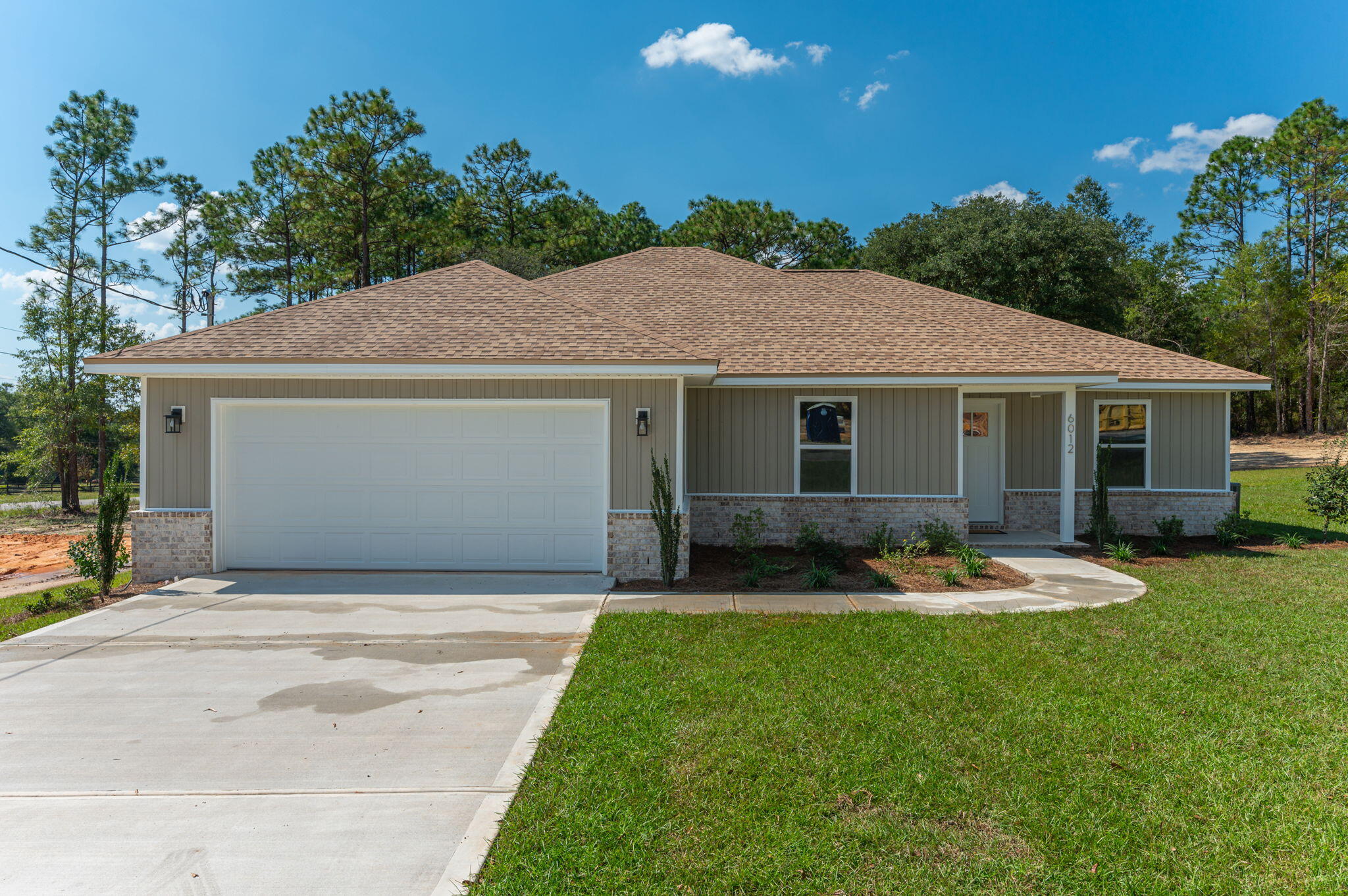 a front view of a house with a garden and yard