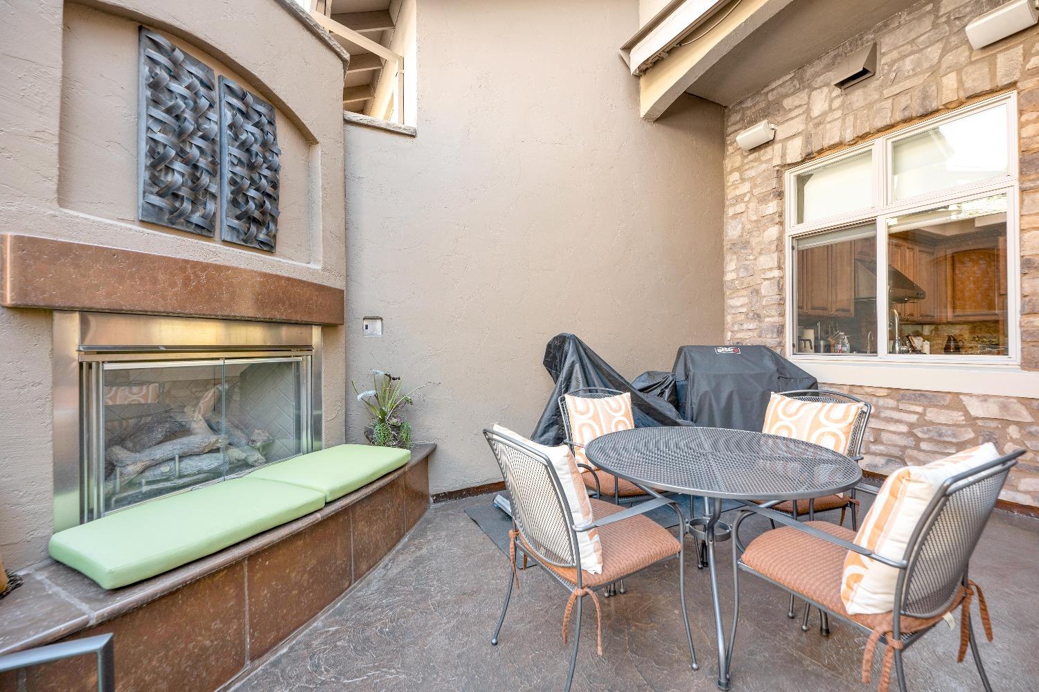 ENTRY PATIO AREA FEATURING GAS STARTER FIREPLACE AND RAISED HEARTH