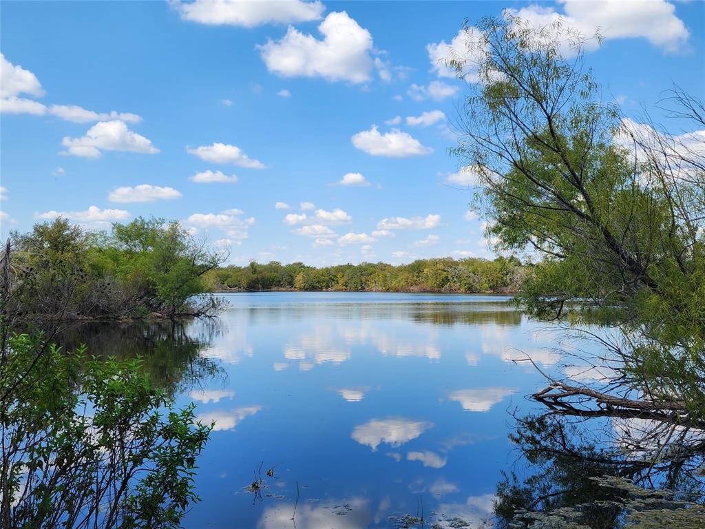 a view of a lake in between two and trees