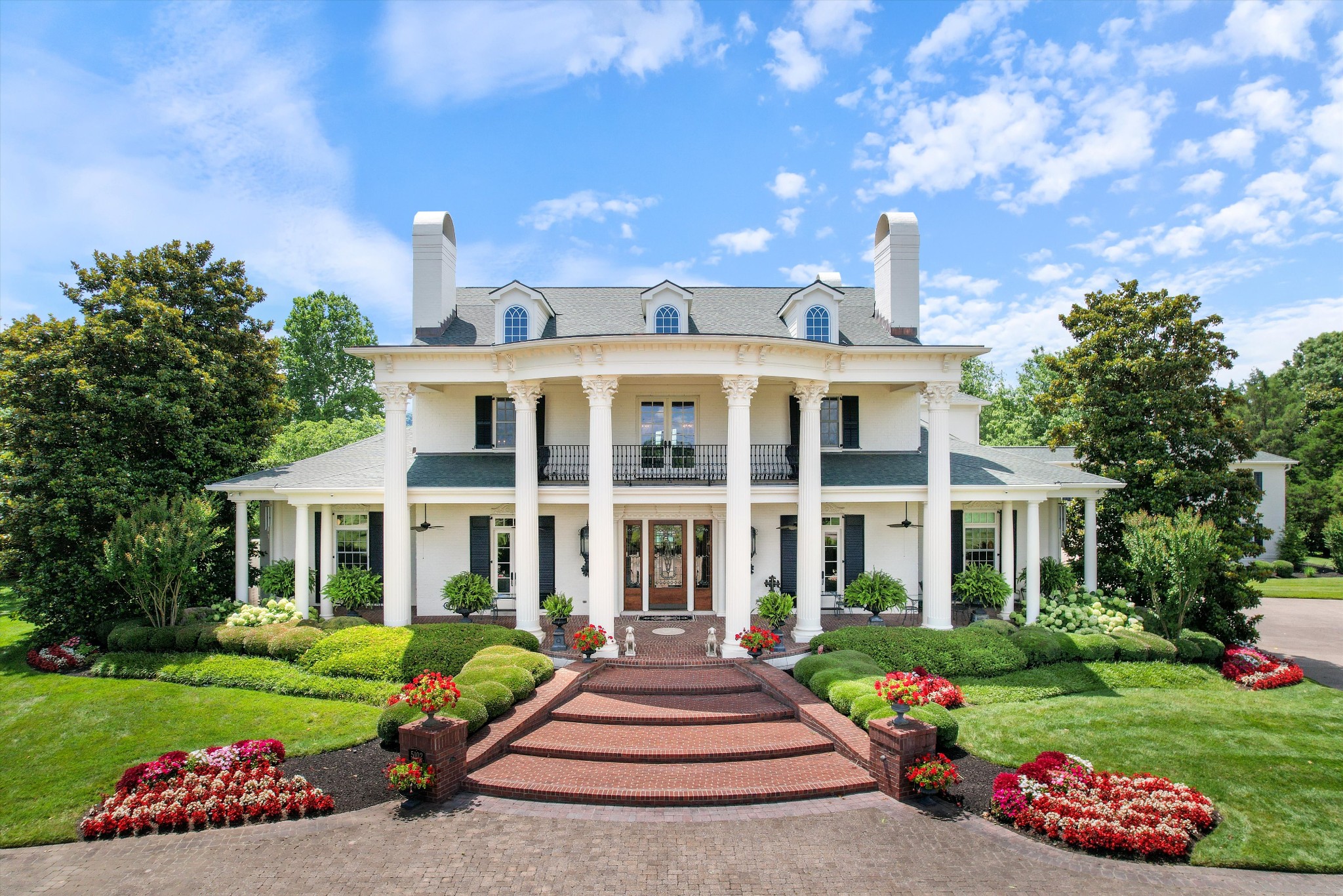 a front view of a house with garden and porch