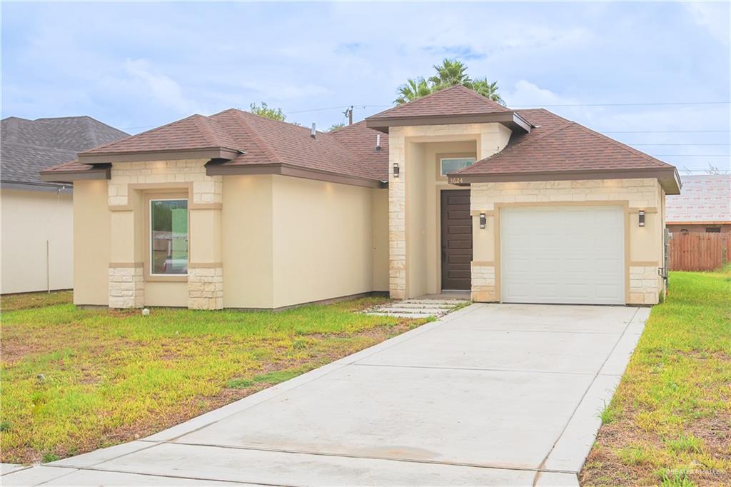 Prairie-style home with a garage and a front lawn